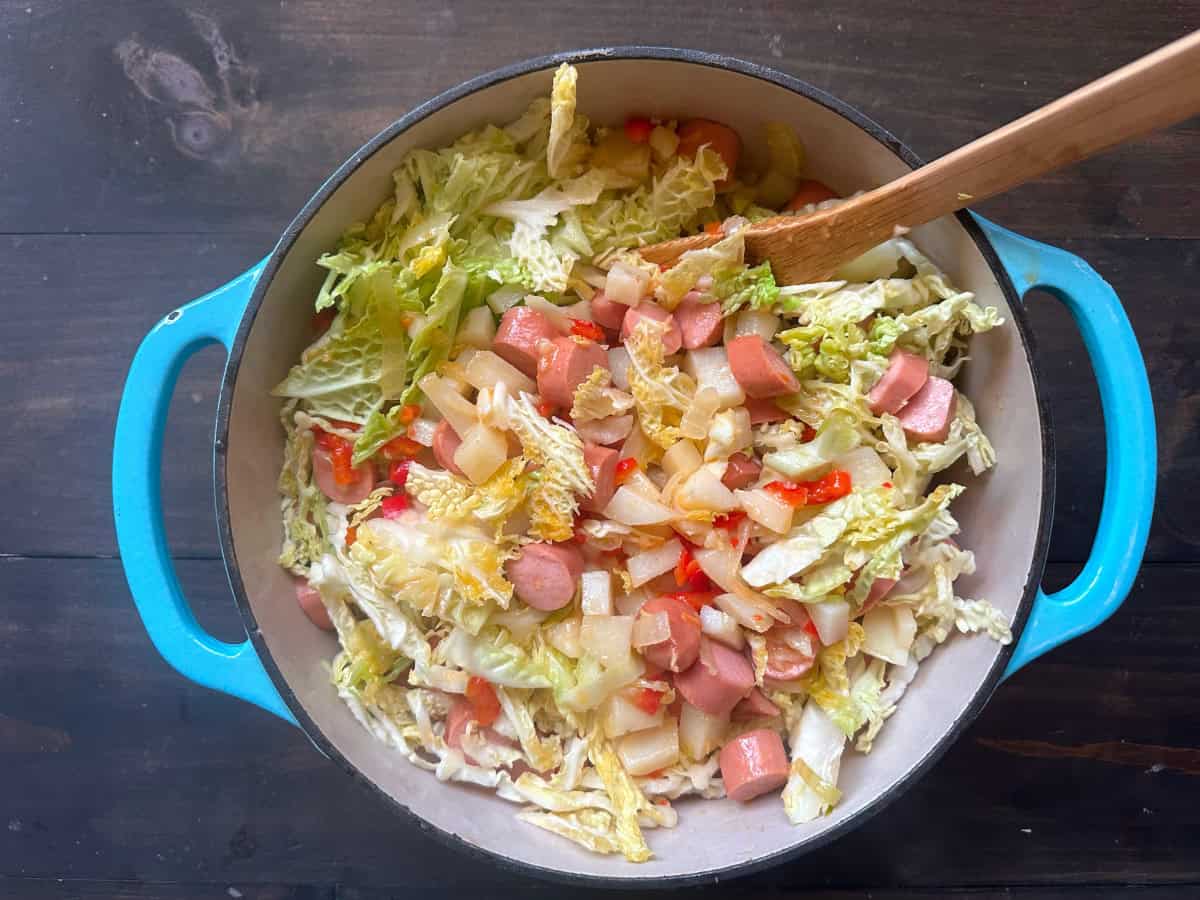 The cabbage and hot dogs added to the veggie mixture.
