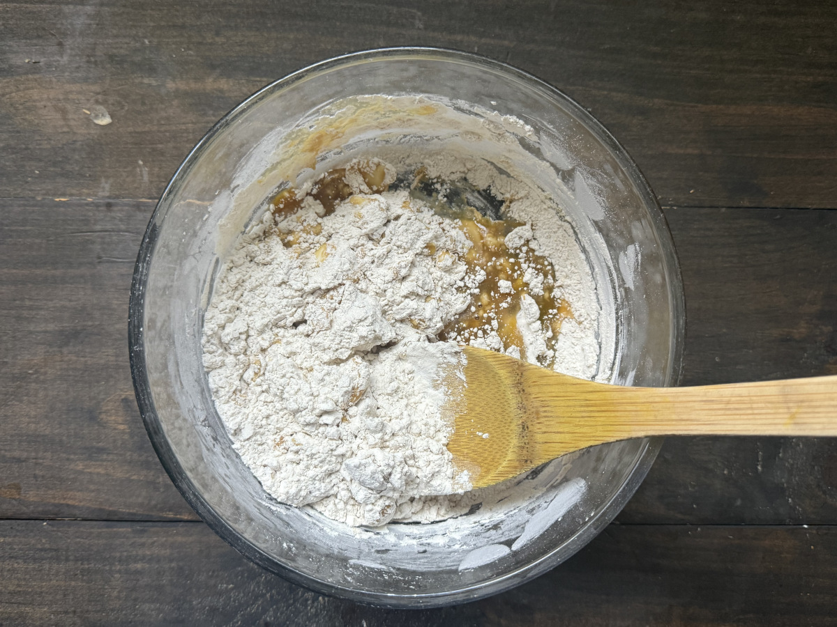 The wet and dry ingredients being mixed together in a bowl.