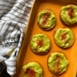 A platter of guacamole sliders with a towel.