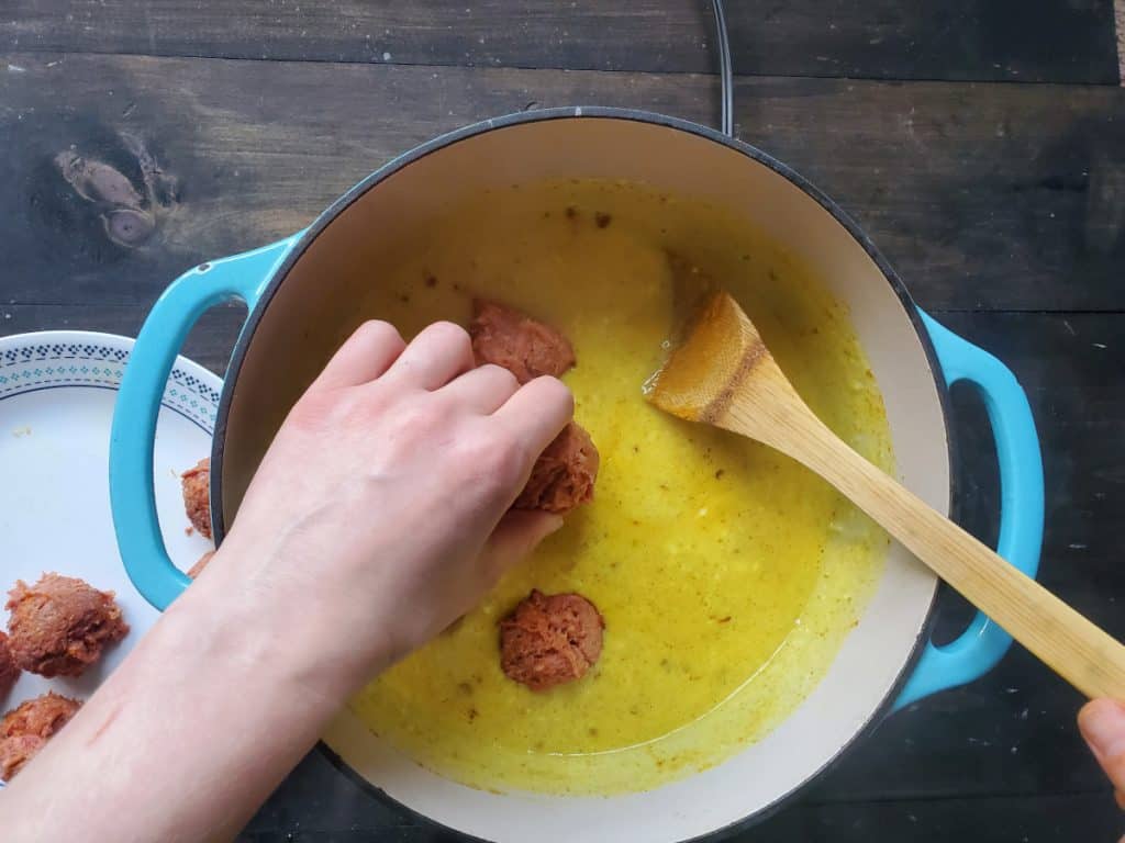 placing the meatballs into the sauce