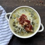 A bowl of potato leek and bacon soup, topped with parmesan,