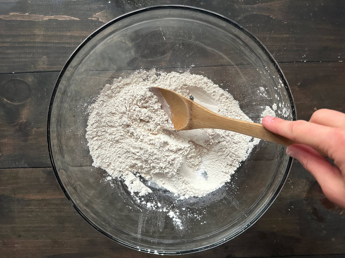 The dry ingredients being mixed together with a wooden spoon.