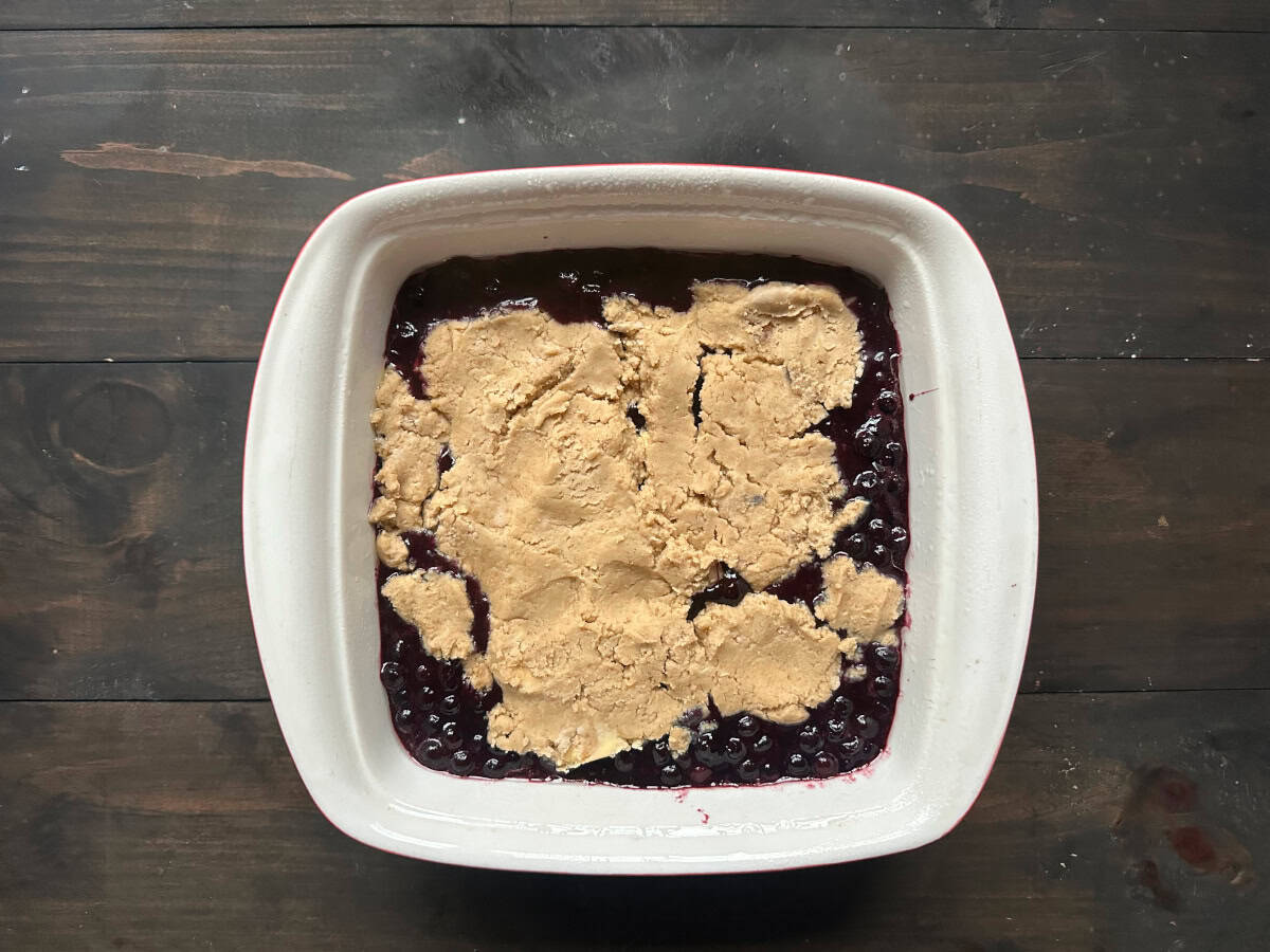 The cobber dough on top of the blueberry mixture ready to be baked.
