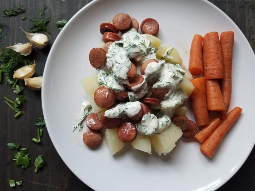Whole30 Ranch Dressing served over roasted potatoes and hot dogs. 