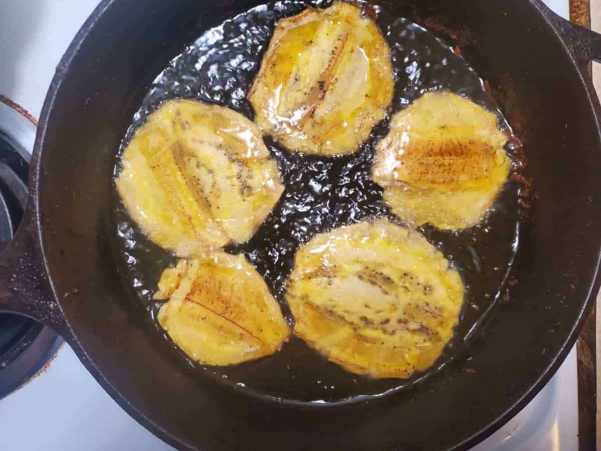 The smashed plantains in the frying pan.