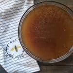 A bowl of slow cooker broth with a towel near by,