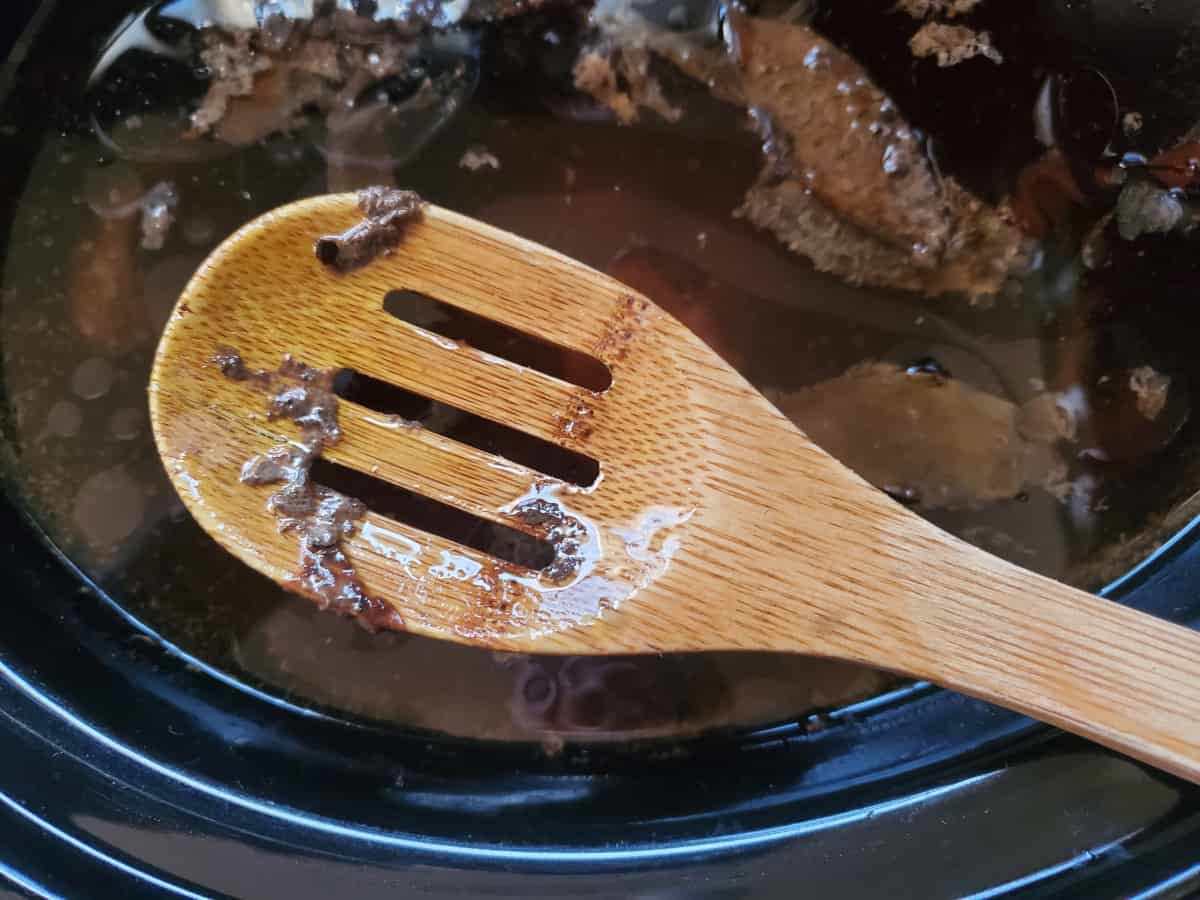 A wooden spoon with bone impurities on it.