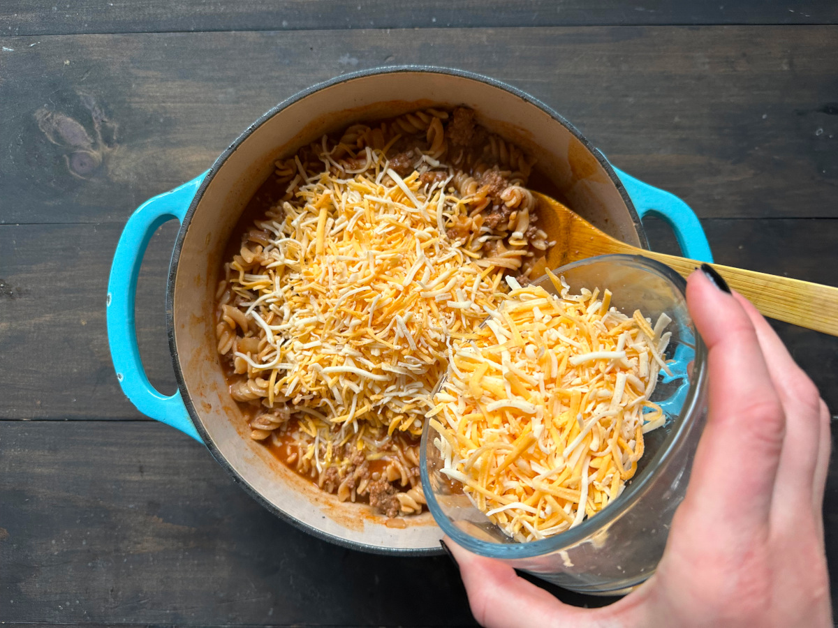Cheese being added to a pasta dish.