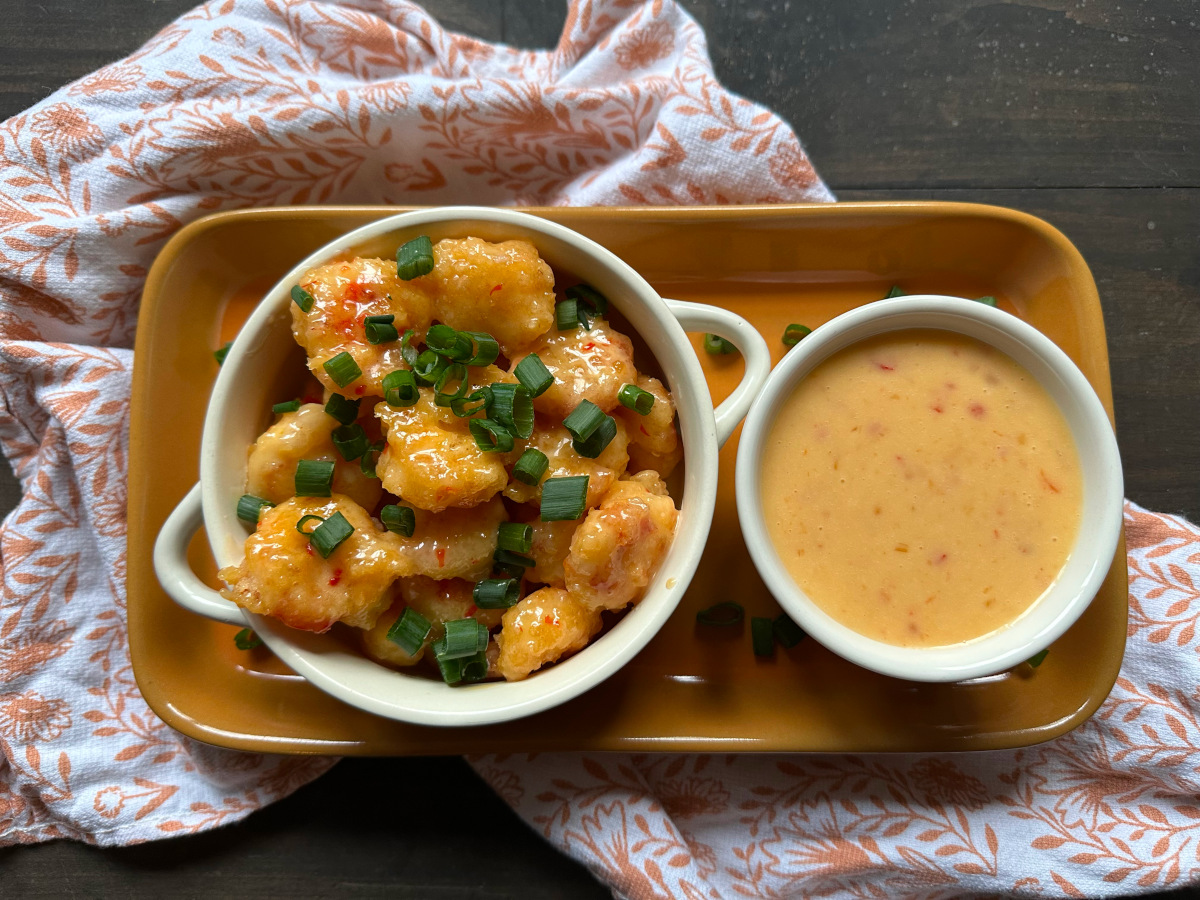 Bang Bang Shrimp with sauce on the side on a tray on a towel.