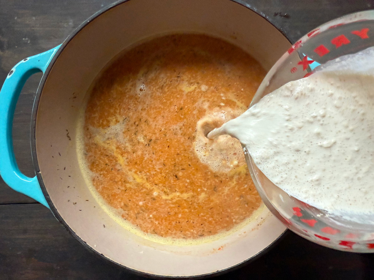 The cream and flour mixture being added into the soup.