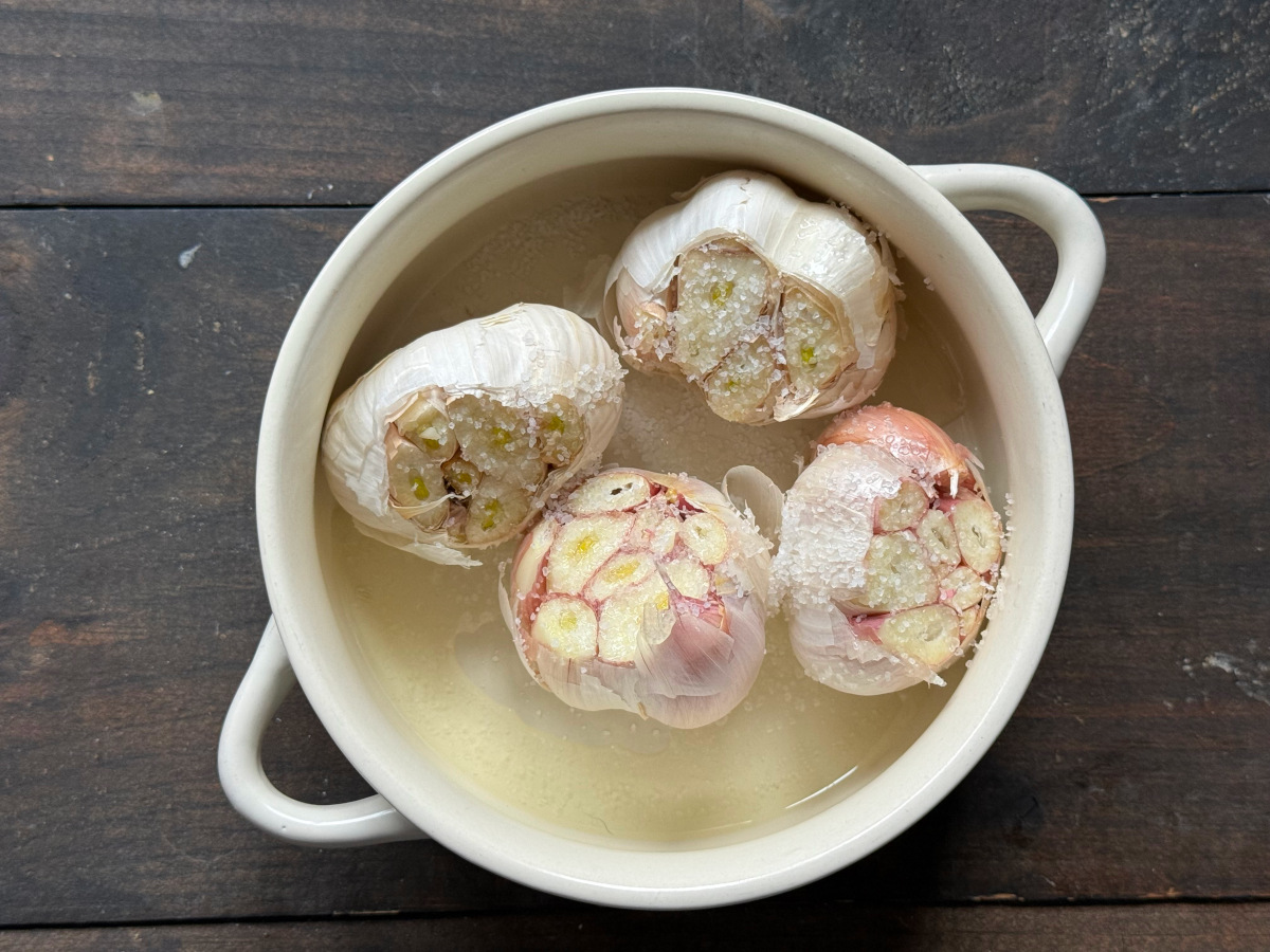 garlic prepared to be roasted in a bowl.